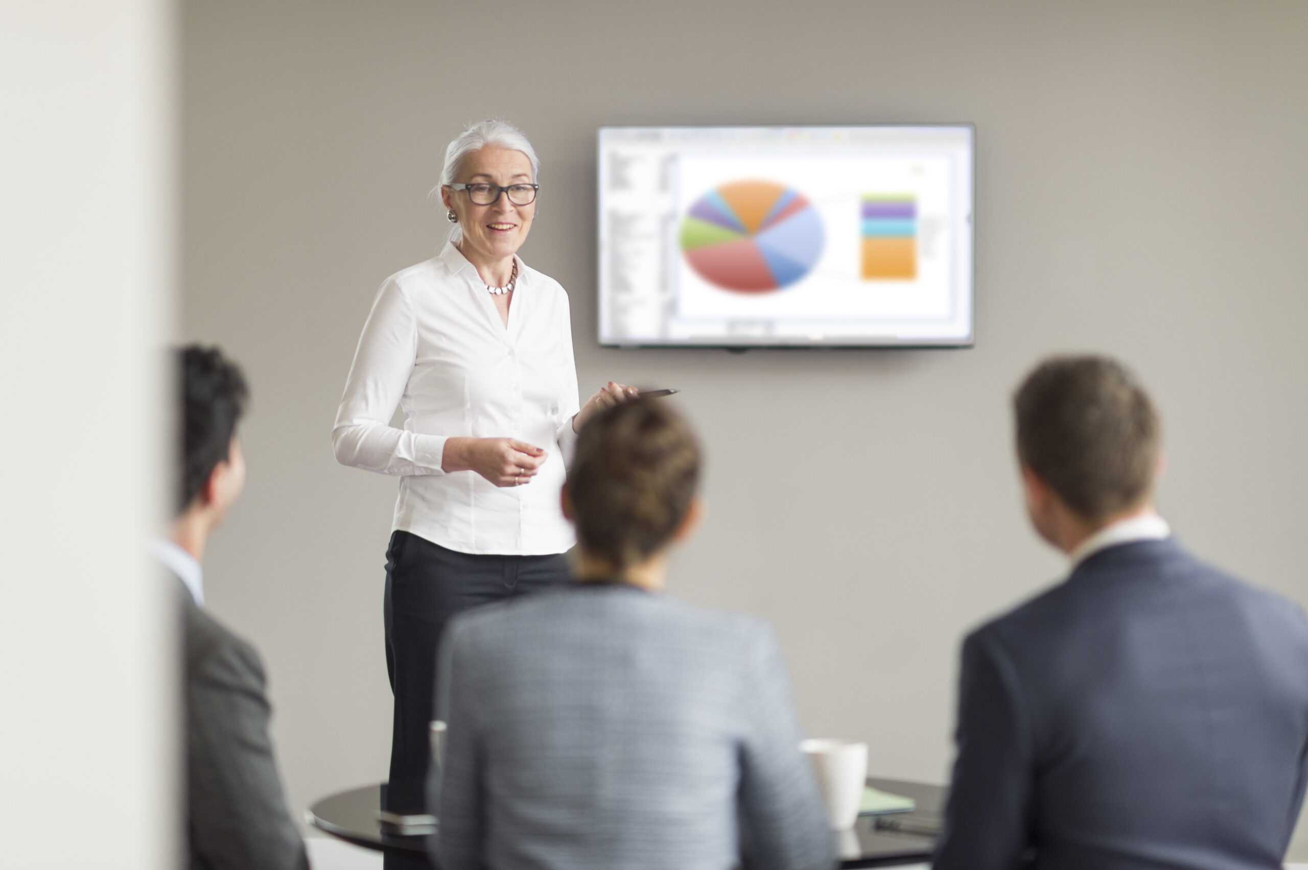 Biografické dokumenty 4 - FerkoMedia Video marketing FerkoMedia - Over shoulder view of mature businesswoman giving office presentation